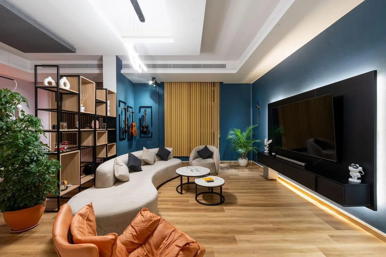 Blue-walled BarCoe Studios lounge with sofa and wall-mounted guitars
