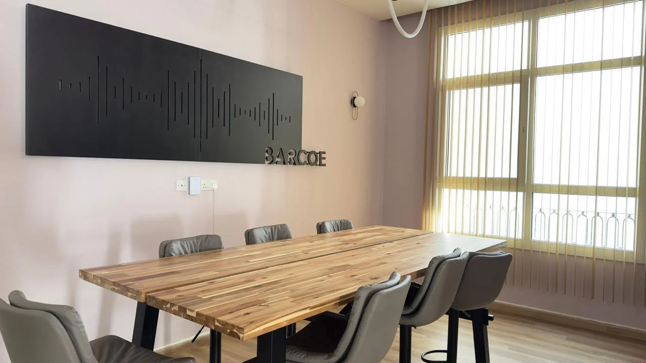BarCoe Studios meeting room with wooden table and BARCOE wall sign